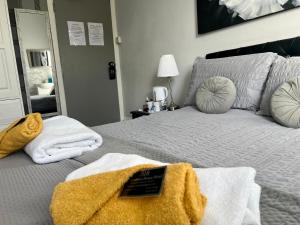 1 dormitorio con 1 cama con toallas en St Andrews house Hotel, en Preston