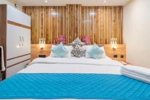 a bedroom with a large white bed with blue pillows at HOTEL SM PARADISE in Visakhapatnam