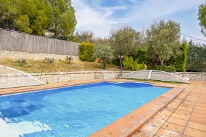 a swimming pool in a backyard with a fence and trees at VentuRural in Venturada