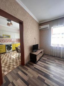 a room with a kitchen with a table and a television at Miracle Gabala villa in Gabala