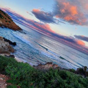 a view of the ocean with a sunset at La Rosa dei Venti B&B in Chia