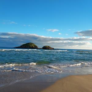 two rocks in the ocean with a sandy beach at La Rosa dei Venti B&B in Chia