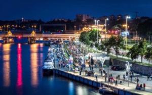 um grupo de pessoas caminhando ao longo de um rio à noite em 9Hanza Tower Studio POOL SAUNA JACUSSI em Szczecin