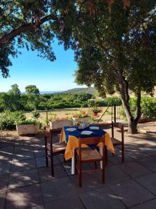 a table and two chairs with a blue table cloth at La Rosa dei Venti B&B in Chia