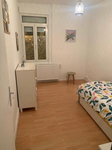 1 dormitorio con cama, mesa y ventana en Logement entier 100 m2, en Sin-le-Noble