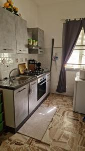 una cucina con lavandino e piano cottura forno superiore di Patty’s house a Sorso