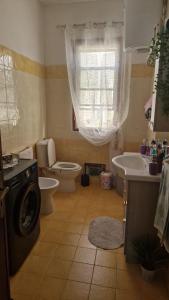ein Badezimmer mit einem Waschbecken und einer Waschmaschine in der Unterkunft Patty’s house in Sorso