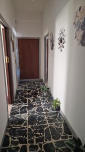 un corridoio con pavimento in pietra di fronte a una porta di Patty’s house a Sorso
