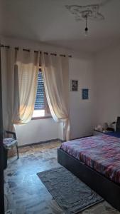 Schlafzimmer mit einem Bett und einem Fenster in der Unterkunft Patty’s house in Sorso