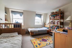 a bedroom with two beds and a book shelf at Green Park in Bath