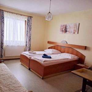 um quarto com uma cama com uma cabeceira em madeira e uma janela em Almgasthof Spitzer em Sankt Stefan ob Leoben