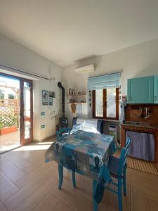 a living room with a table and a kitchen at Sa dommo de Mammai in Cala Gonone