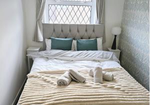 a white bed with towels on it with a window at Walderslade Serviced Accommodation Medway Maidstone in Kent