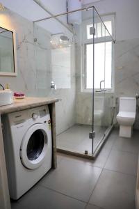 a bathroom with a washing machine and a shower at Heritage Home in Central Kolkata in Kolkata