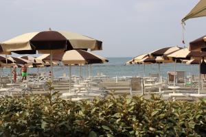 a beach with chairs and umbrellas and the ocean at Appartamento Lungomare Toscanelli in Lido di Ostia