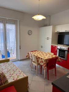 a kitchen with a table and chairs and red cabinets at Casa Francesca in Albissola Marina +29 photos