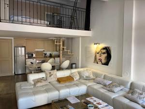 a living room with a white couch and a kitchen at Appartement trois pièces Saint Tropez in Saint-Tropez