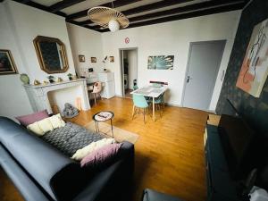 una sala de estar con un sofá y una mesa en 1 Apt Des Artistes, 3 min À Pied Gare et Centre, en Valenciennes