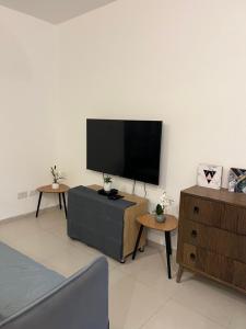 uma sala de estar com uma televisão de ecrã plano na parede em דירת גן מדרך עוז Garden Apartment em Midrakh ‘Oz