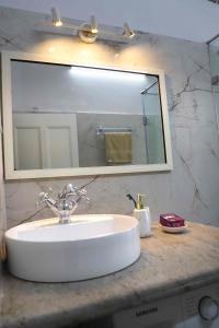 a bathroom sink with a large mirror above it at Heritage Home in Central Kolkata in Kolkata