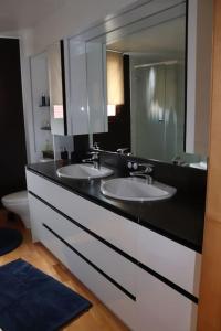 La salle de bains est pourvue de 2 lavabos et d'un grand miroir. dans l'établissement Le DorliSchopf gîte 2 étoiles, à Dorlisheim