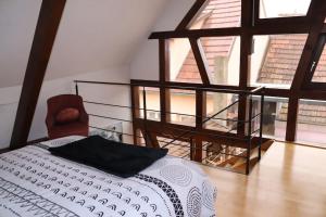 - une chambre avec un lit et une grande fenêtre dans l'établissement Le DorliSchopf gîte 2 étoiles, à Dorlisheim