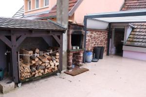 une pile de bois de feu à l'intérieur d'un garage dans l'établissement Le DorliSchopf gîte 2 étoiles, à Dorlisheim