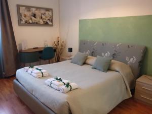 a bedroom with a large bed with towels on it at Brà Guest House in Verona