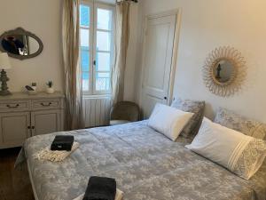 サントロペにあるAppartement trois pièces Saint Tropezのベッドルーム1室(枕2つ、鏡付)