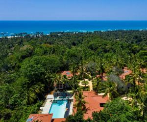 高尔Tabula Rasa Resort & Spa的带游泳池和大海的度假村的鸟瞰图