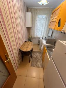 eine kleine Küche mit einem Holztisch und einem kleinen Tisch in der Unterkunft Cozy & warm studio in Bukarest