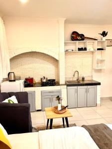 eine Küche und ein Wohnzimmer mit einem Sofa und einem Tisch in der Unterkunft Cozy Studio Apartment in Daressalam