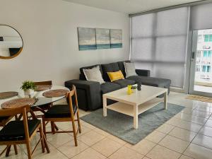 a living room with a couch and a table at Isla Verde Beach Modern apartment in San Juan