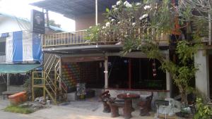 een gebouw met een patio met een tafel en een balkon bij Crazy Monkey in Trat