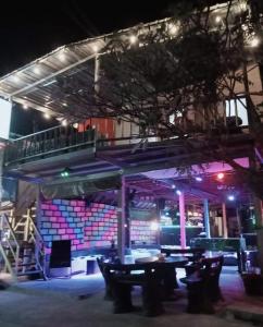 een restaurant met een balkon en tafels voor een gebouw bij Crazy Monkey in Trat