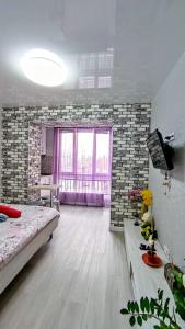 - une chambre avec un lit et une grande fenêtre dans l'établissement Миниотель в Харькове, ЮЖД, à Kharkov