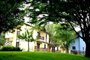 a large white house with trees in the foreground at VONRESORT Abant in Dereceören