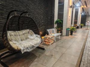 a wicker chair sitting in a hallway with a bench at Puchong HELLO KITTY FULLY AIR-CON Suite in Puchong