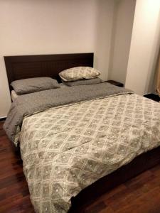um quarto com uma cama grande e um edredão em Pine Heights Luxury Apartment em Islamabad