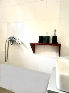 ein Bad mit einer Dusche und einem Waschbecken in der Unterkunft Cozy Studio Apartment in Daressalam