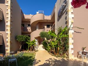 a view of the side of a building with tables and chairs at Matzi Hotel Apartments in Gerani
