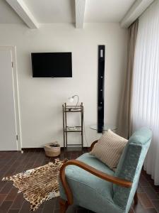 een woonkamer met een bank en een tv aan de muur bij Ferienappartement Hennen in Konz