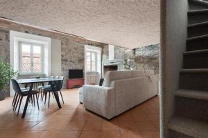 uma sala de estar com um sofá, uma mesa e cadeiras em [Vista Duomo] Cuore di Como em Como