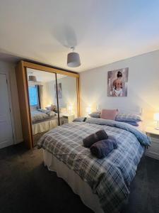 a bedroom with two beds and a large mirror at 50 Gordon Terrace in Invergordon