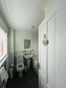 Baño blanco con aseo y lavamanos en 50 Gordon Terrace en Invergordon