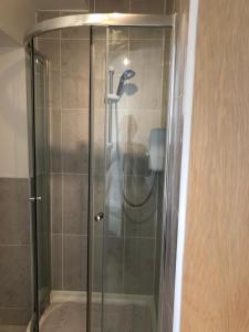 een douche met een glazen deur in de badkamer bij Weston Court in Avonmouth