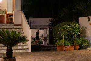 Un homme descend les escaliers d'un immeuble avec des plantes dans l'établissement Villa Crimi, à Vulcano