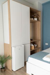 a white refrigerator in a bedroom next to a bed at Oyster Apartments in Sarandë