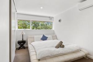 - une chambre blanche avec un lit blanc et une fenêtre dans l'établissement Luxury spacious 3-bedroom Suite on exclusive Lansell Rd, Toorak, à Melbourne