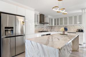 La cuisine est équipée d'un comptoir en marbre et d'un réfrigérateur. dans l'établissement Luxury spacious 3-bedroom Suite on exclusive Lansell Rd, Toorak, à Melbourne